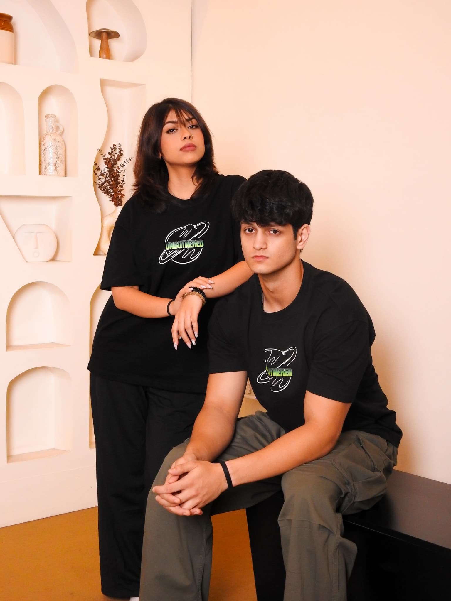 Couple in Unbothered tees — studio portrait